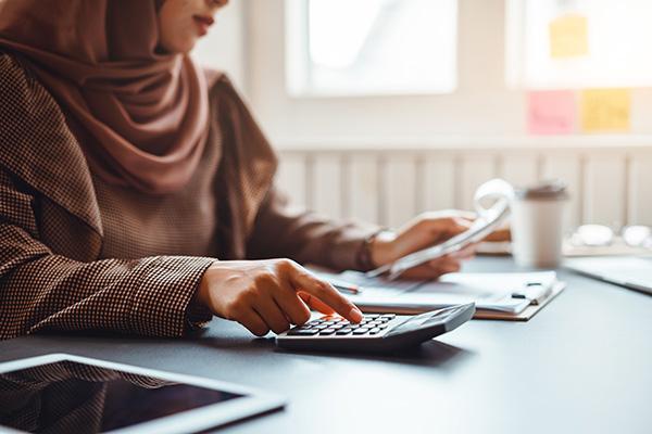 woman typing on calculator